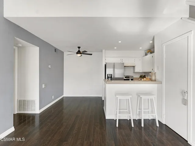 a kitchen with wooden floors and refrigerator