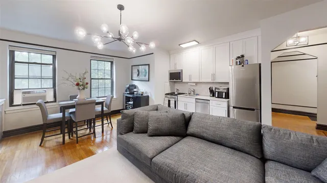 a living room with furniture dining table and a chandelier