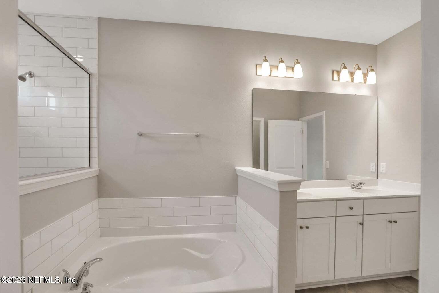 65 Torres Trace Street St. Augustine, FL 32095 - Photo 16 of 32 a bathroom with a bathtub shower sink and mirror