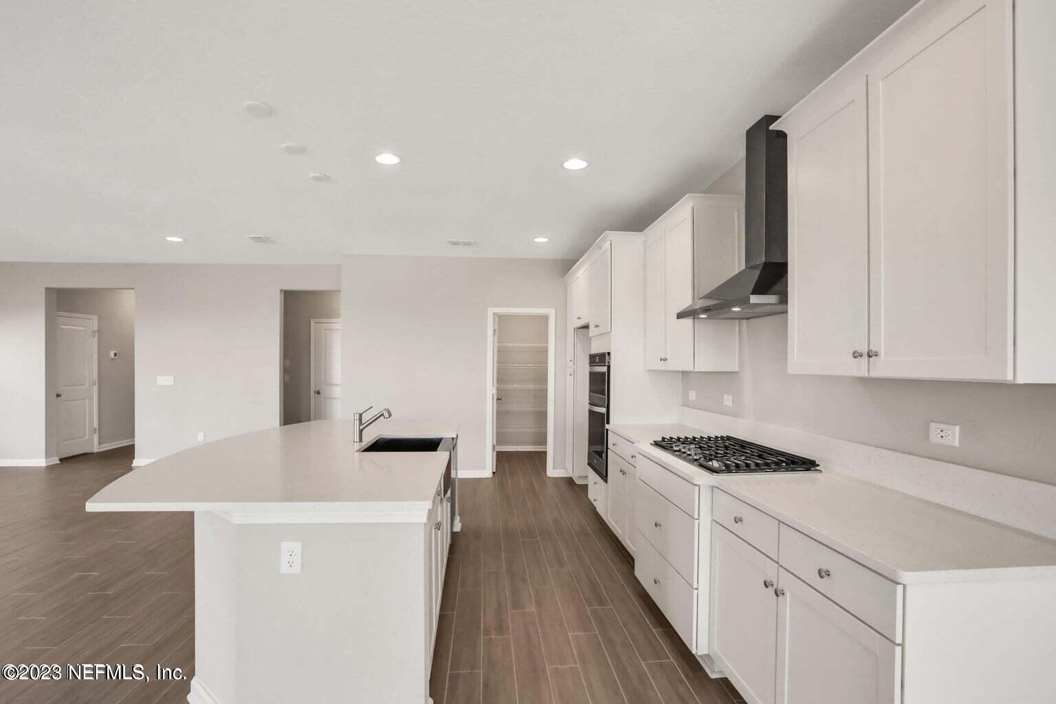 65 Torres Trace Street St. Augustine, FL 32095 - Photo 4 of 32 a kitchen with granite countertop a sink stove and cabinets