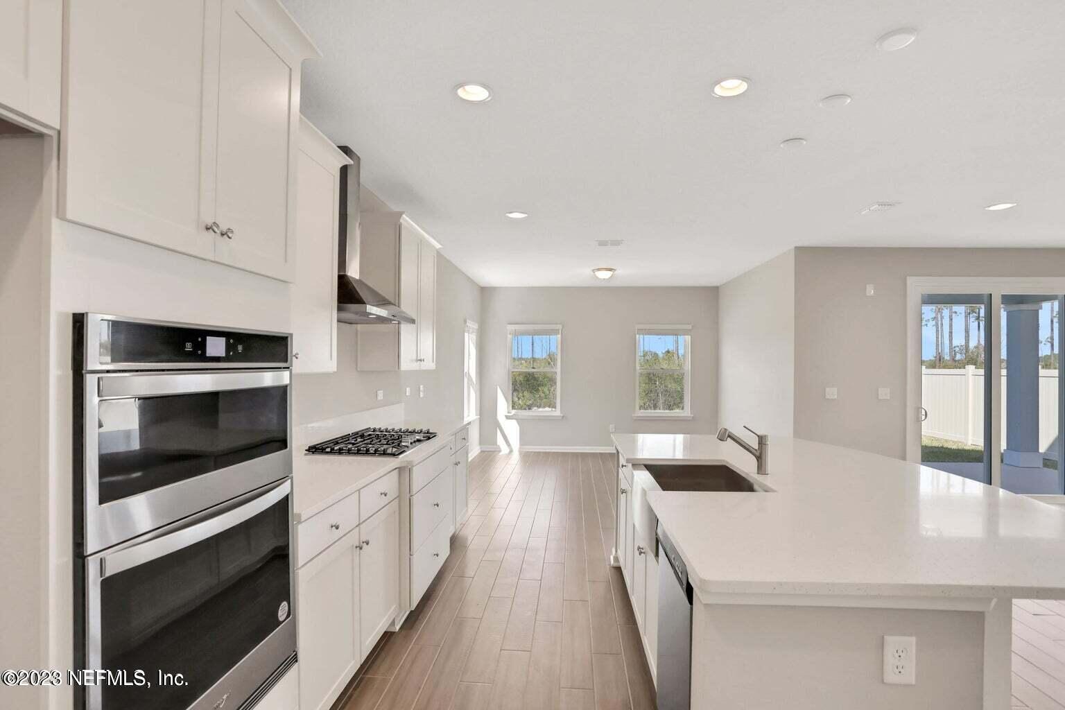 65 Torres Trace Street St. Augustine, FL 32095 - Photo 5 of 32 a kitchen with granite countertop white cabinets and white appliances