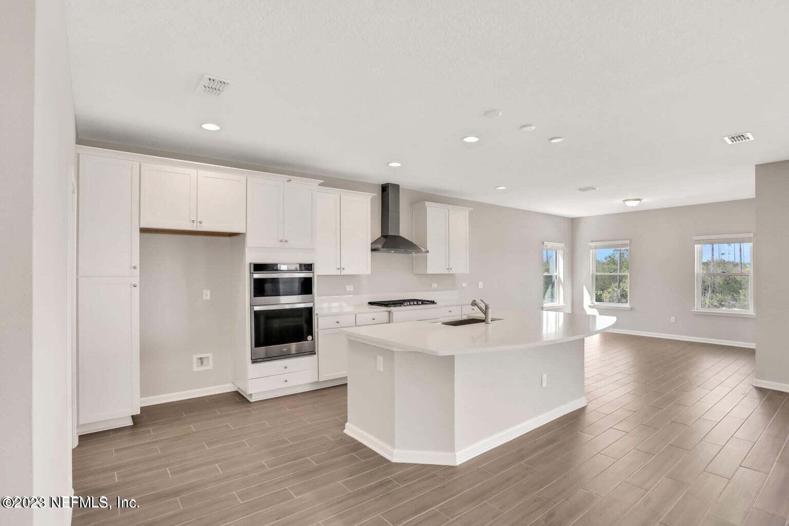 65 Torres Trace Street St. Augustine, FL 32095 - Photo 7 of 32 a large kitchen with cabinets and wooden floor