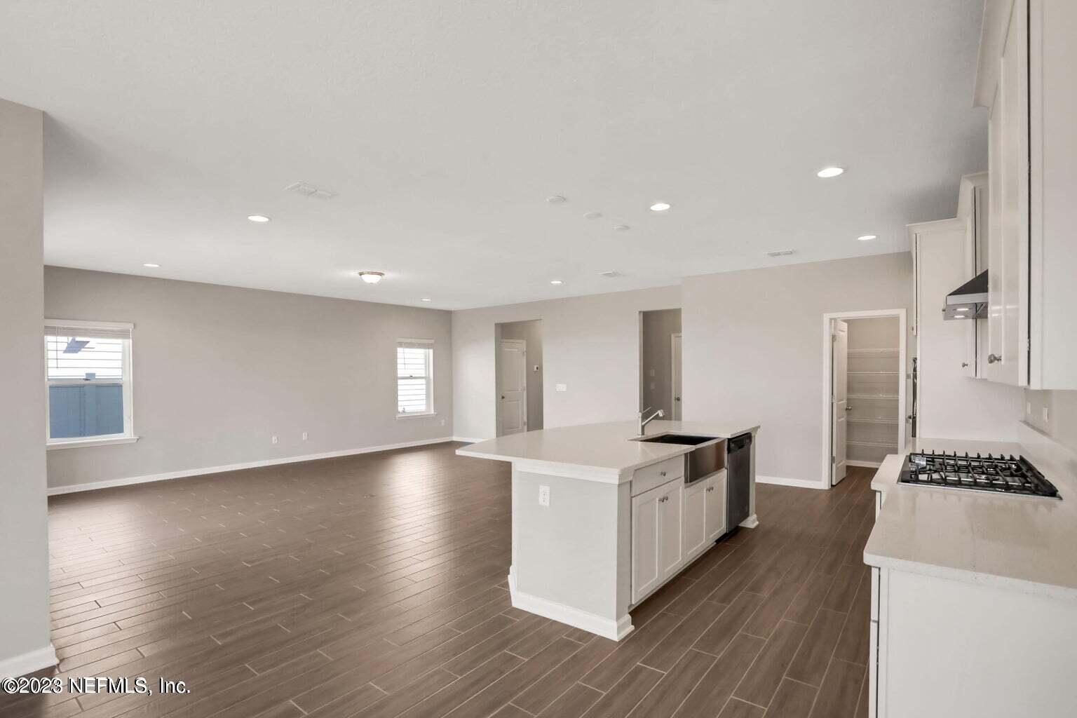 65 Torres Trace Street St. Augustine, FL 32095 - Photo 9 of 32 a kitchen with stainless steel appliances granite countertop a sink stove and wooden floor