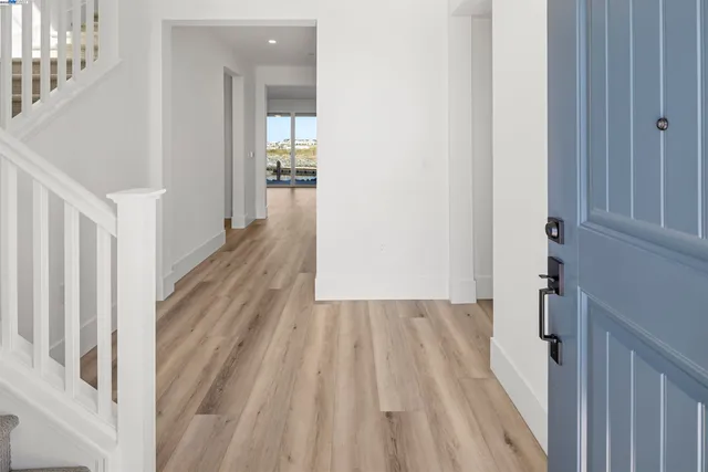 a view of a hallway with wooden floor and staircase