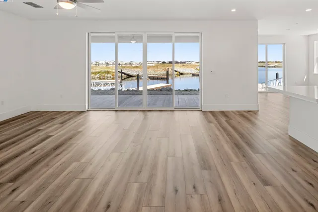 an empty room with wooden floor and a large window