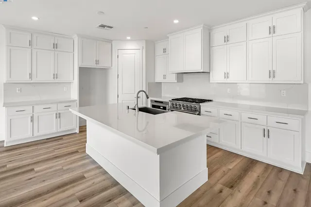 a kitchen with white cabinets and sink