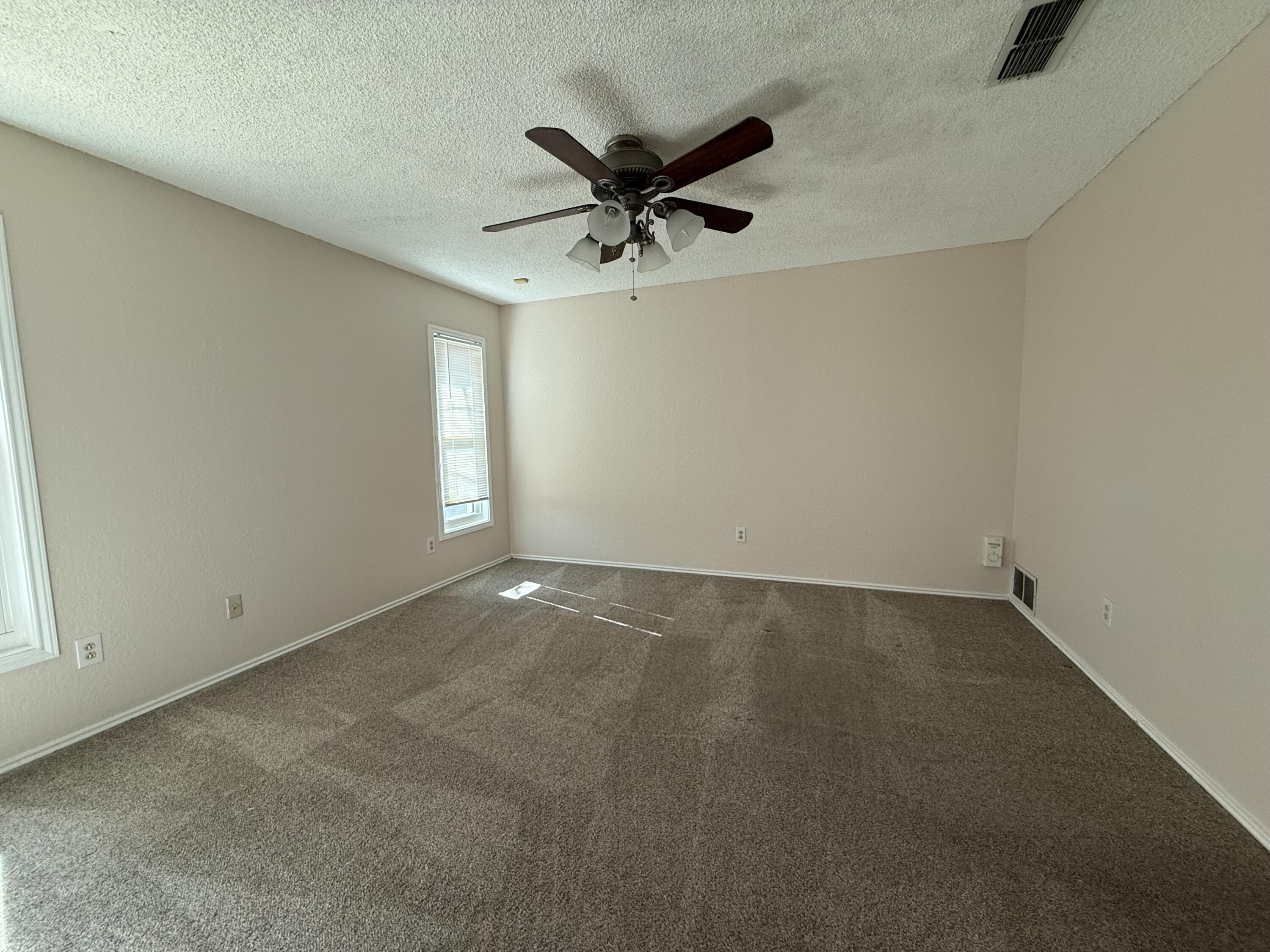 5729 89th Street Lubbock, TX 79424 - Photo 7 of 15 an empty room with a ceiling fan and window