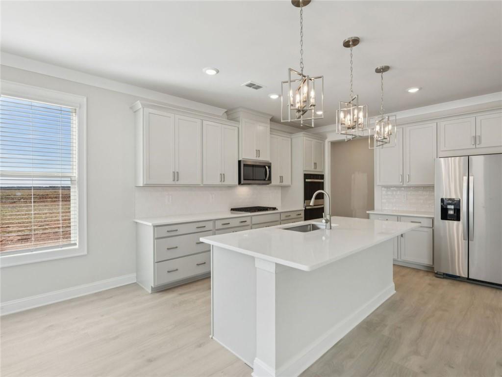 1291 Whitman Circle Monroe, GA 30656 - Photo 6 of 22 a kitchen that has a lot of white cabinets and stainless steel appliances