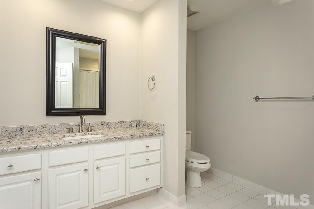 1305 Canfield Court Raleigh, NC 27608 - Photo 26 of 30 a bathroom with a granite countertop sink toilet and mirror