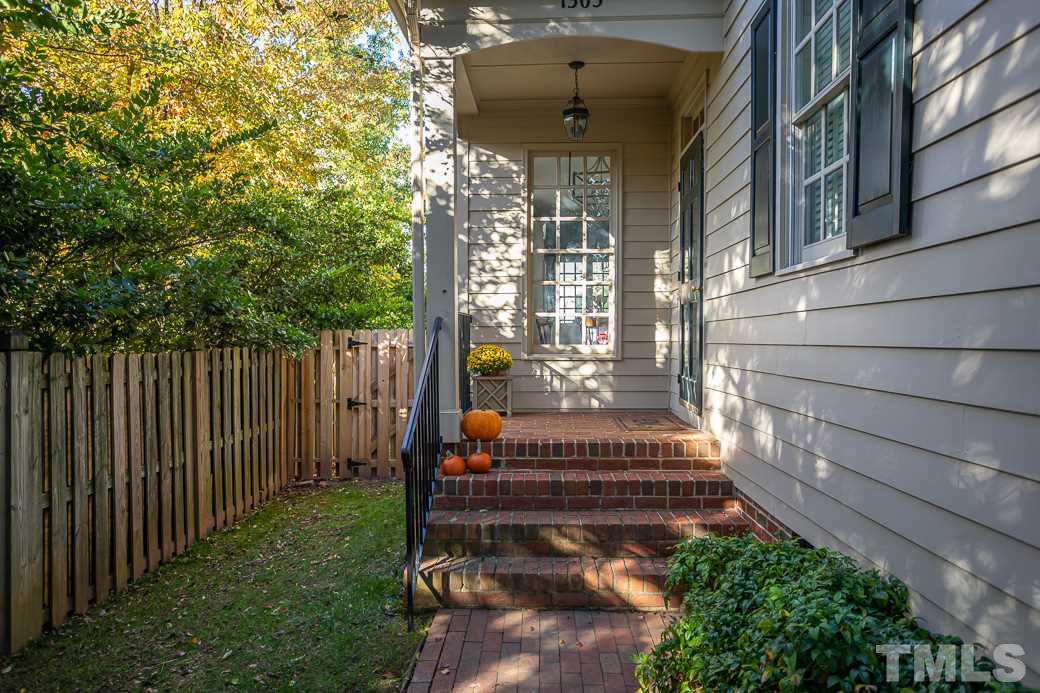 1305 Canfield Court Raleigh, NC 27608 - Photo 5 of 30 a view of a house with a small yard and wooden floor and fence