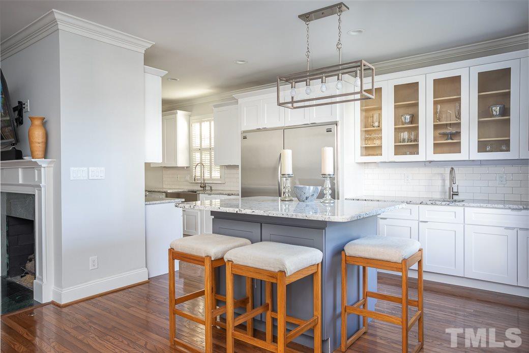 1305 Canfield Court Raleigh, NC 27608 - Photo 10 of 30 a kitchen with a dining table chairs cabinets and stainless steel appliances