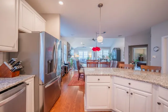a kitchen with stainless steel appliances granite countertop a sink refrigerator and cabinets