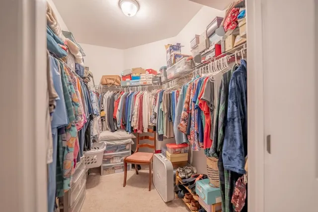 a view of walk in closet with clothes