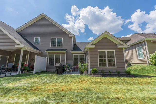 a view of a house with a big yard and large trees