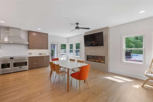 a living room with stainless steel appliances kitchen island granite countertop a stove and a wooden floor