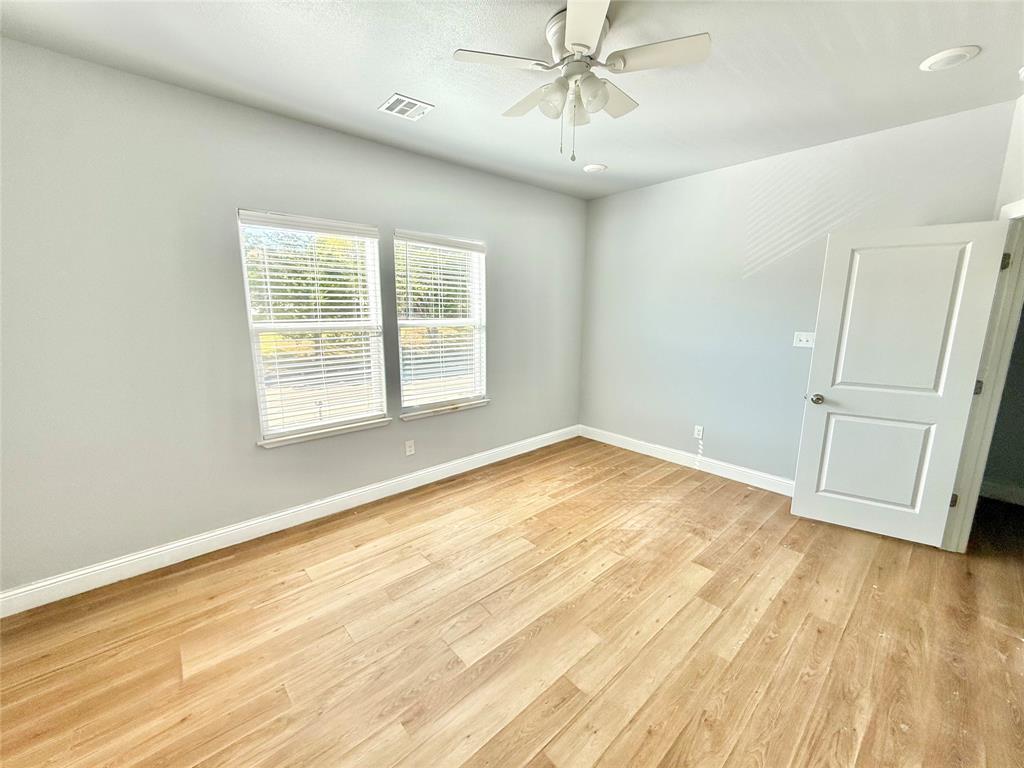 986 South 6th Avenue, Unit 988 Denison, TX 75021 - Photo 10 of 15 an empty room with wooden floor fan and windows