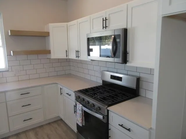 a kitchen with white cabinets and appliances