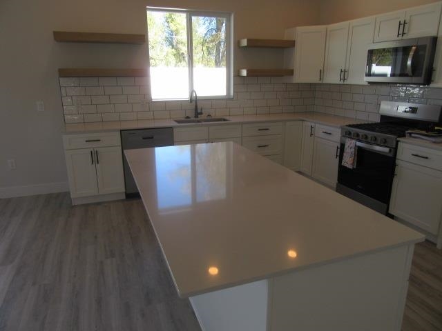 2468 Revere Road Grand Junction, CO 81505 - Photo 5 of 26 a kitchen with granite countertop a sink a stove a microwave and cabinets