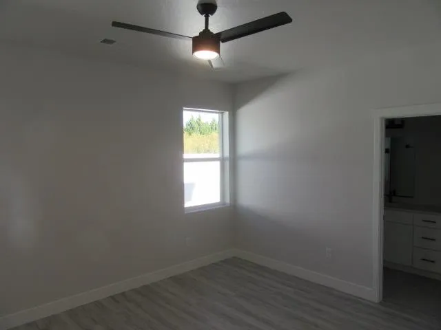 an empty room with a window and wooden floor