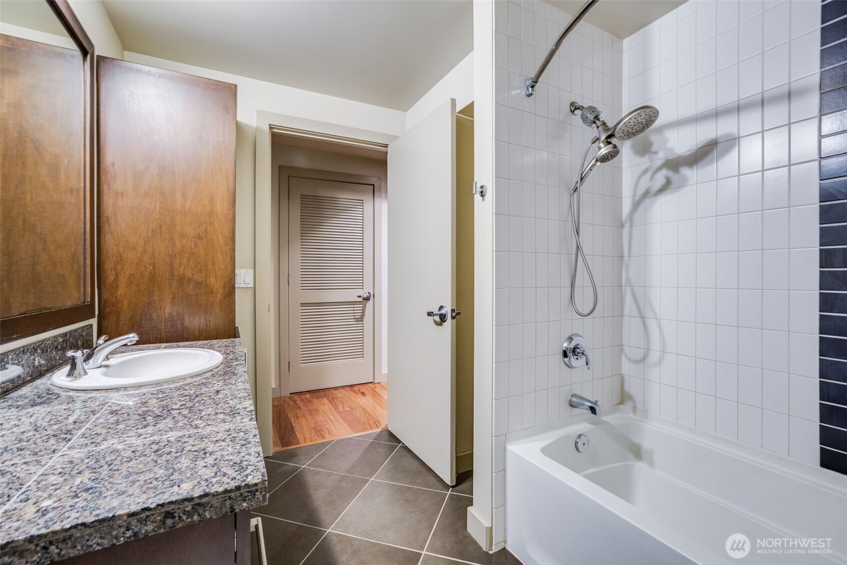900 Lenora Street, Unit W803 Seattle, WA 98121 - Photo 15 of 29 a bathroom with a granite countertop sink and a bathtub