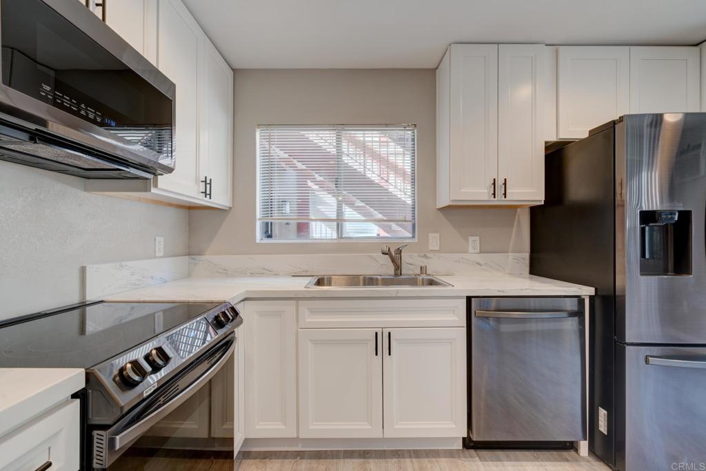 5432 Adobe Falls Road, Unit 3 San Diego, CA 92120 - Photo 1 of 1 a kitchen with stainless steel appliances a sink stove and refrigerator