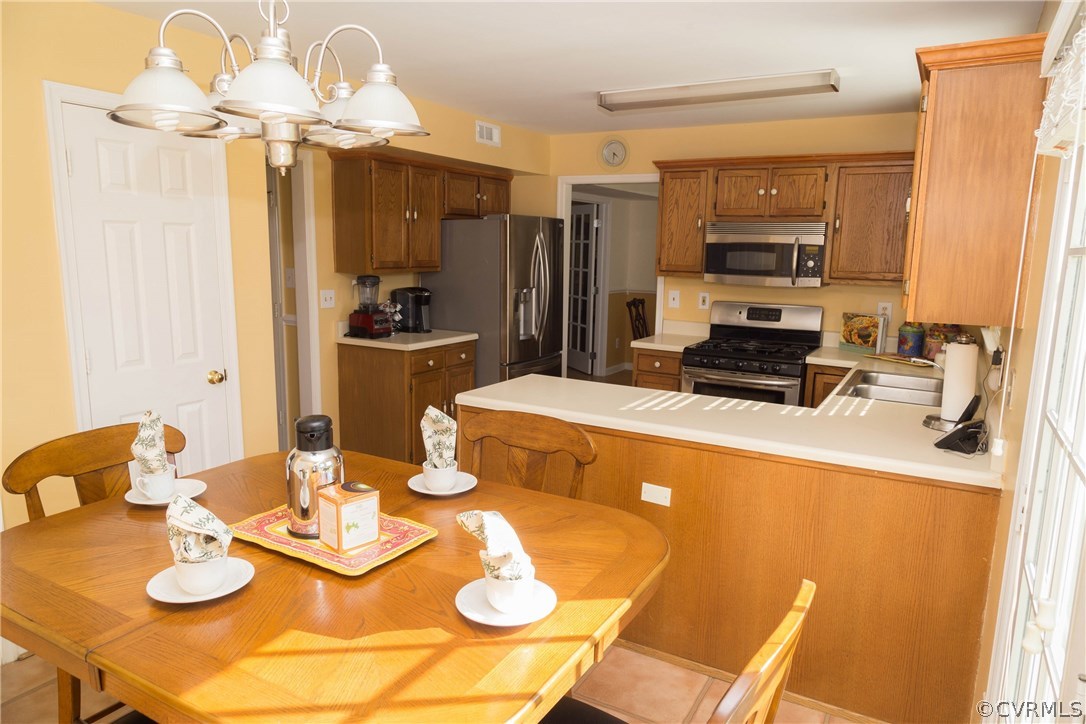 3200 Ransom Hills Road Richmond, VA 23237 - Photo 7 of 20 a kitchen with stainless steel appliances kitchen island granite countertop a table and chairs in it