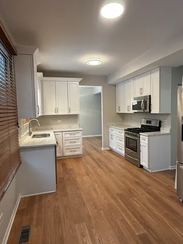 a kitchen with stainless steel appliances a stove a sink and a microwave