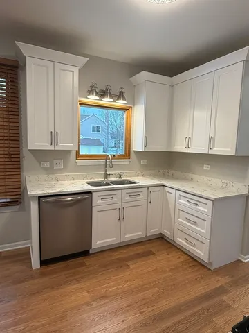 a kitchen with granite countertop a sink cabinets and stainless steel appliances