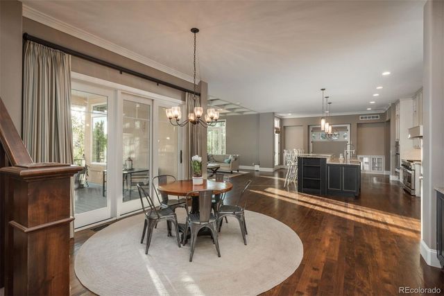 a dining room with furniture a chandelier and kitchen view