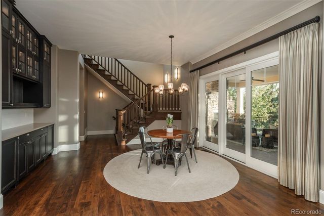 a dining room with furniture a chandelier and wooden floor