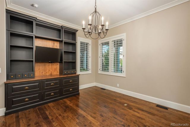a view of room with wooden floor and chandelier