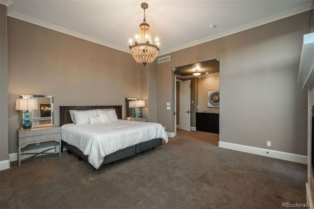 a spacious bedroom with a bed and a chandelier