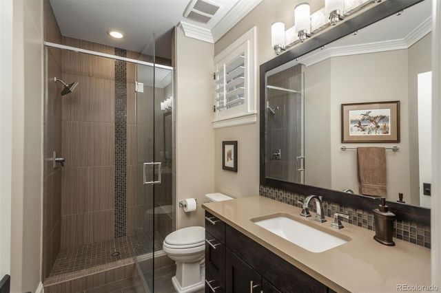 a bathroom with a sink vanity granite toilet and shower