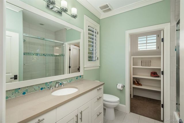 a bathroom with a granite countertop sink a toilet and a mirror