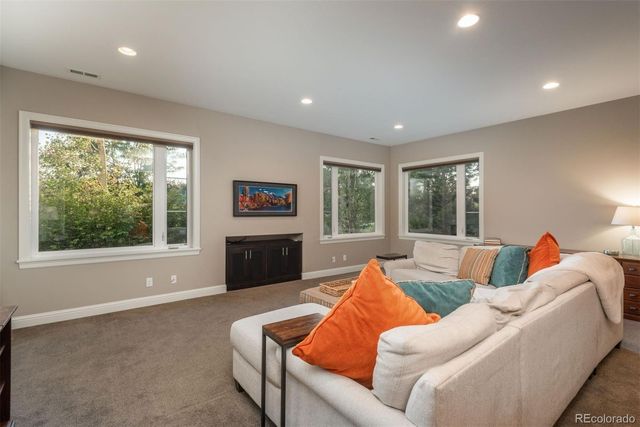 a living room with furniture a large window and a flat screen tv