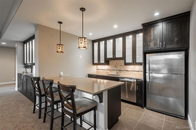 a kitchen with stainless steel appliances granite countertop a sink a stove a refrigerator and island