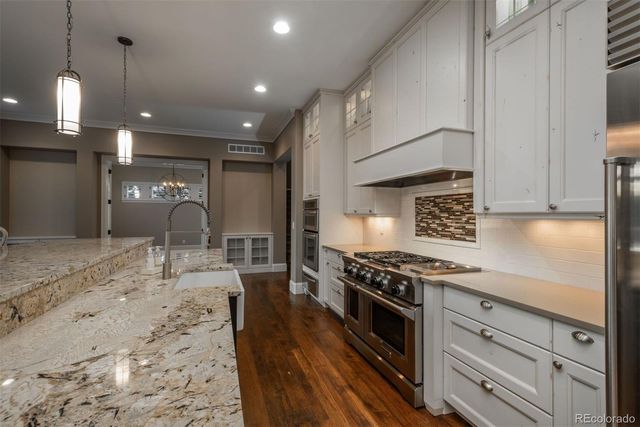 a kitchen with stainless steel appliances granite countertop a stove a sink and a refrigerator