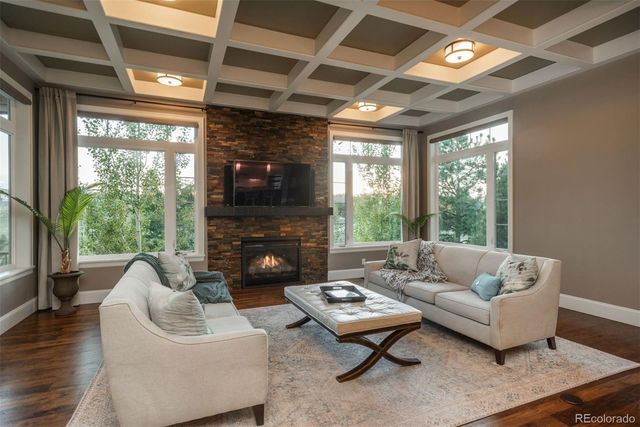 a living room with furniture a fireplace and a floor to ceiling window