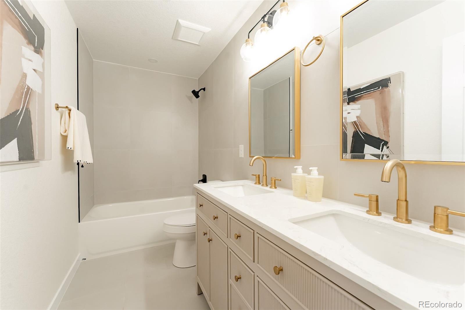 1279 South Raritan Street Denver, CO 80223 - Photo 21 of 25 a bathroom with a double vanity sink toilet mirror and shower