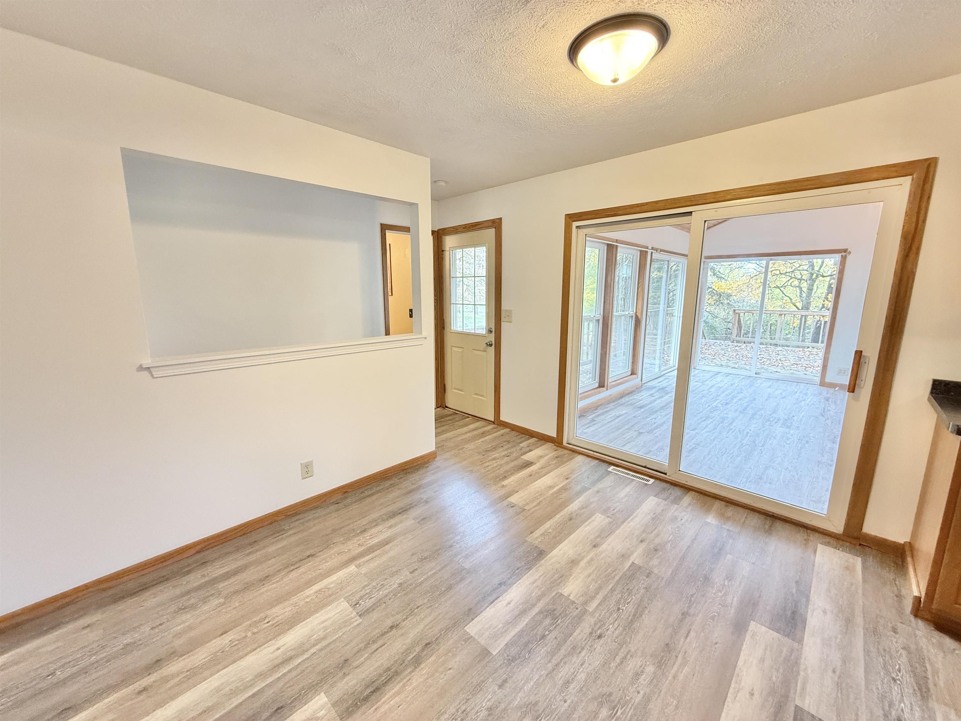 10620 Grover Oaks Road Roscoe, IL 61073 - Photo 17 of 32 an empty room with wooden floor and windows