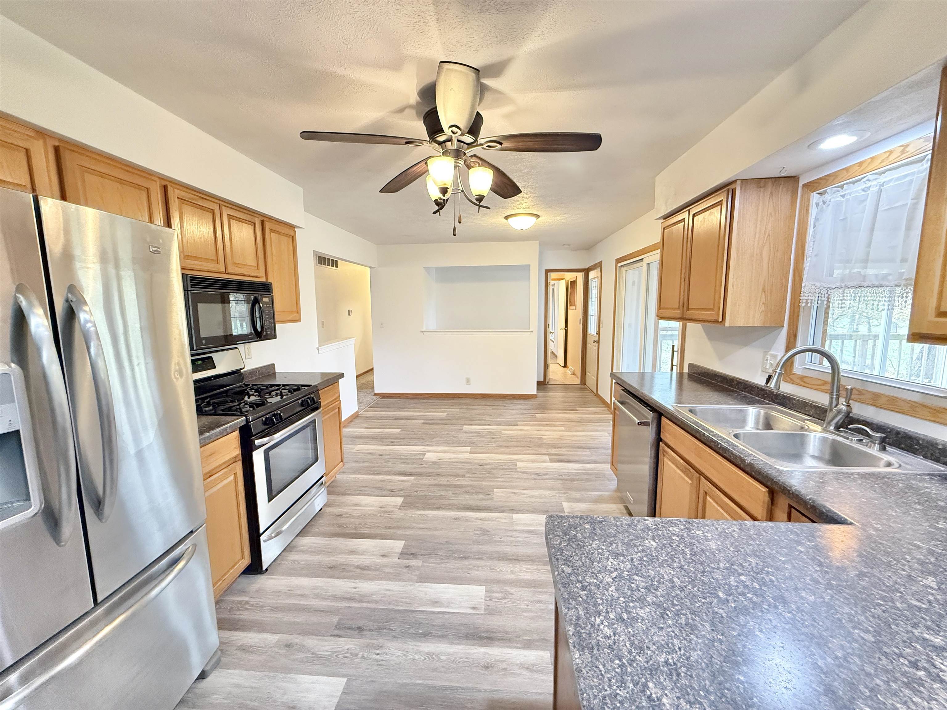 10620 Grover Oaks Road Roscoe, IL 61073 - Photo 3 of 32 a kitchen with stainless steel appliances granite countertop a refrigerator a stove and a sink with cabinets