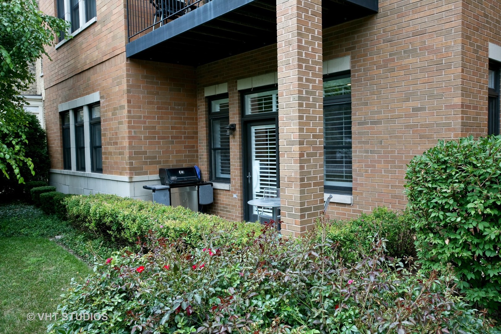 821 Foster Street, Unit 1S Evanston, IL 60201 - Photo 14 of 14 a view of a house with potted plants and a bench
