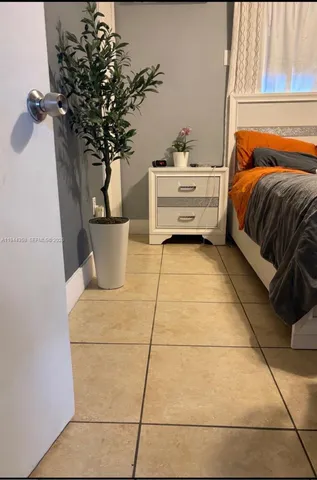 a bedroom with a bed and a potted plant