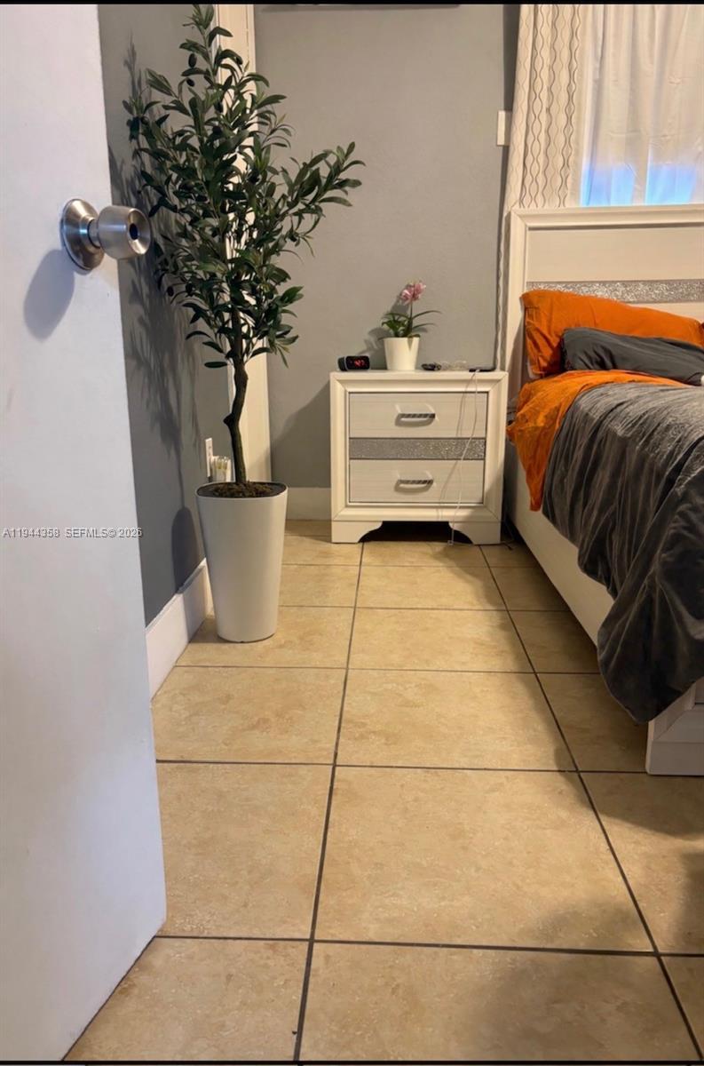 4444 Southwest 67th Avenue, Unit 6 Miami, FL 33155 - Photo 5 of 7 a bedroom with a bed and a potted plant