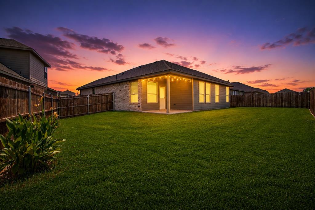 1804 Mensa Drive Haslet, TX 76052 - Photo 28 of 30 Spacious backyard featuring a manicured lawn, full perimeter privacy fencing, and an expansive covered patio