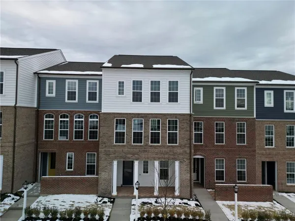 a front view of a building with lot of cars and trees