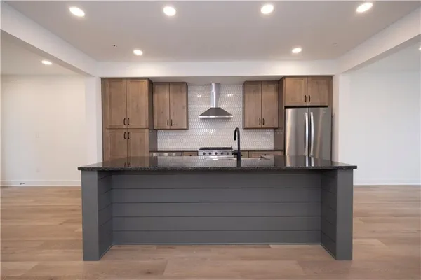 a kitchen with stainless steel appliances granite countertop a refrigerator and a sink