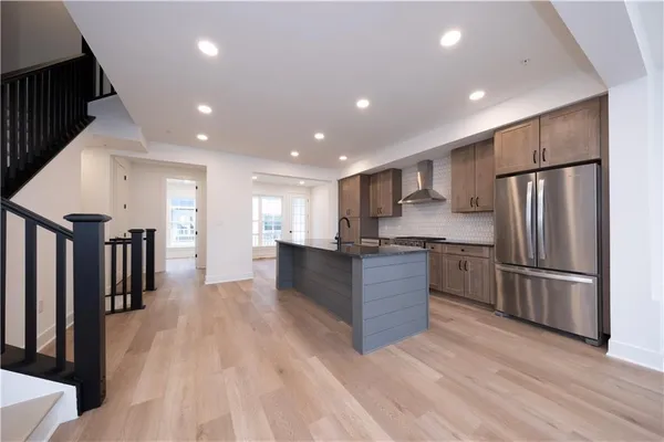 a kitchen with stainless steel appliances granite countertop a refrigerator and a stove top oven