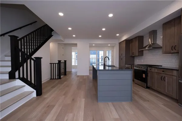 a kitchen with stainless steel appliances granite countertop a refrigerator and a stove top oven