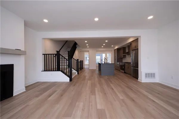 a view of a hallway with wooden floor and staircase
